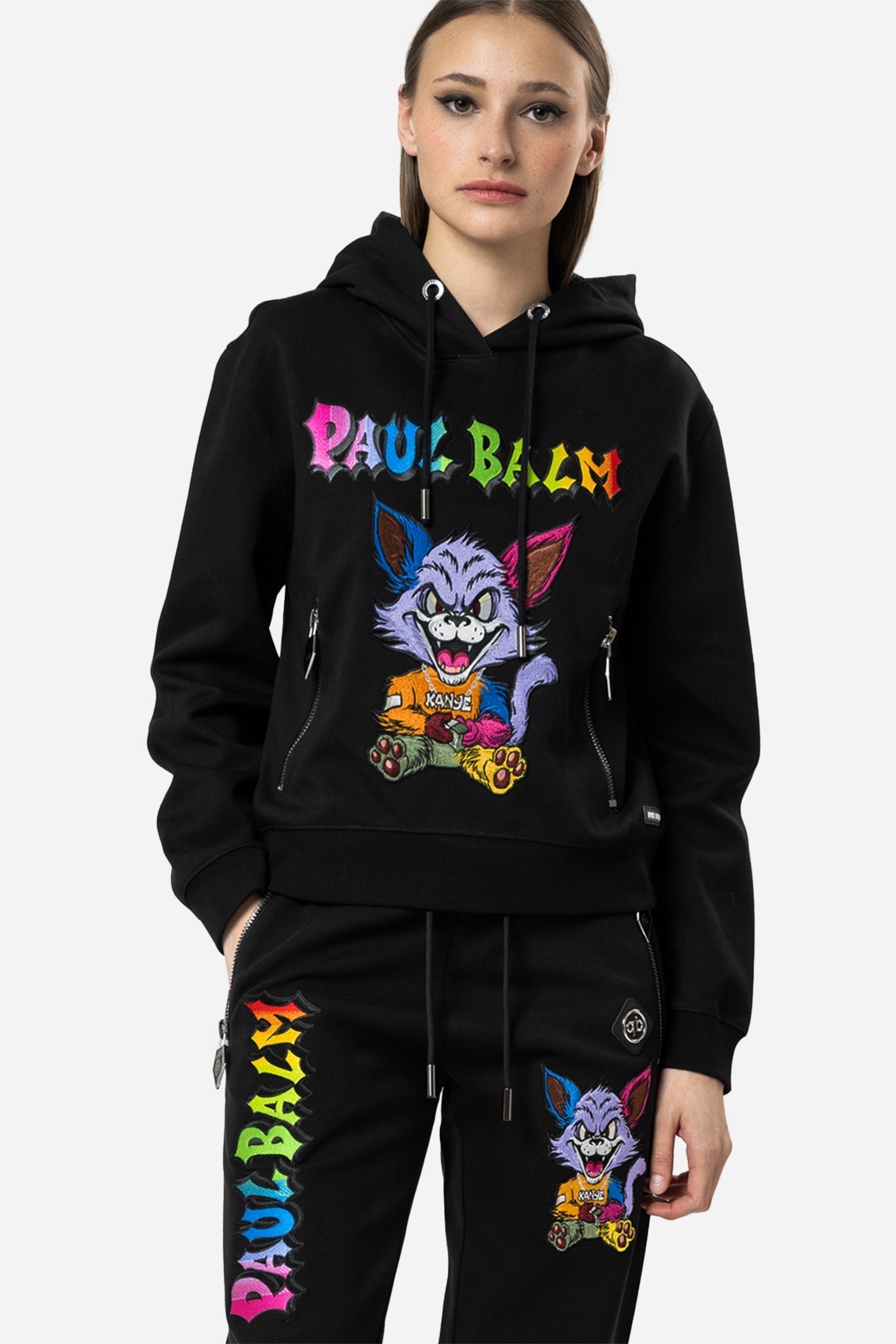 Dieser PAUL BALM Damen Hoodie ist mit unserem bunten Kanye-Stick auf der Vorderseite, und unserem markentypischen Metalllogos verziert. Er ist aus hochwertigem Baumwollmischgewebe gefertigt und ist mit zwei separate Taschen mit Logo-Reissverschlüssen ausgestattet. 